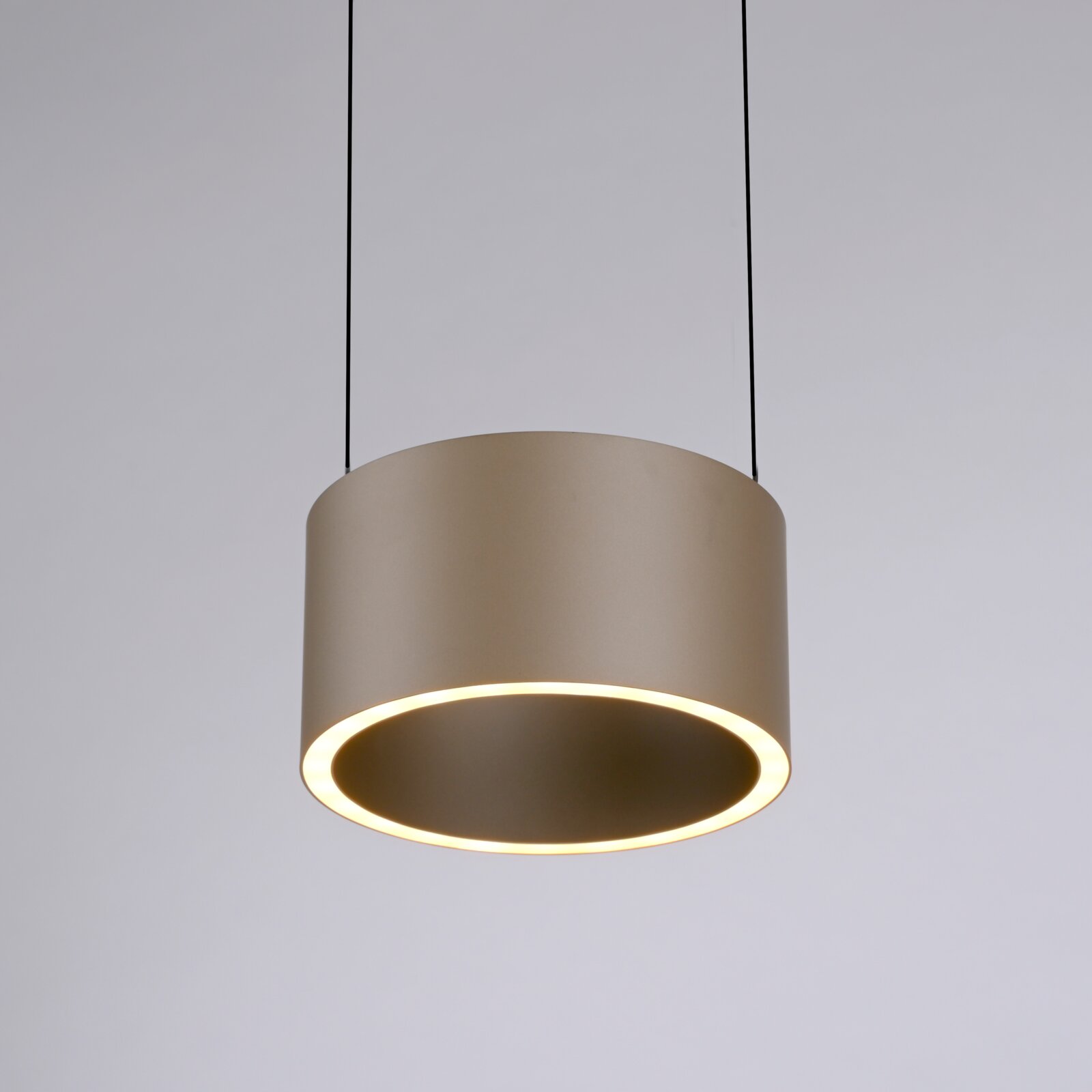 Moderne LED-Pendelleuchte in zylindrischer Form, von unten betrachtet, mit warmem Lichtschein.