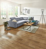 Graues Ecksofa MAROLA in modernem Wohnzimmer, seitliche Perspektive mit Holzboden und großen Fenstern.
