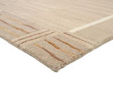 Beige Wollteppich mit dezenten Streifen in verschiedenen Brauntönen, perspektivisch von der Ecke aus fotografiert.