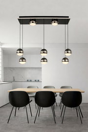 Moderne LED-Pendelleuchte mit mehreren kugelförmigen Lampen, hängend über einem Esstisch in einem stilvollen, minimalistischen Raum. Perspektive von vorne.