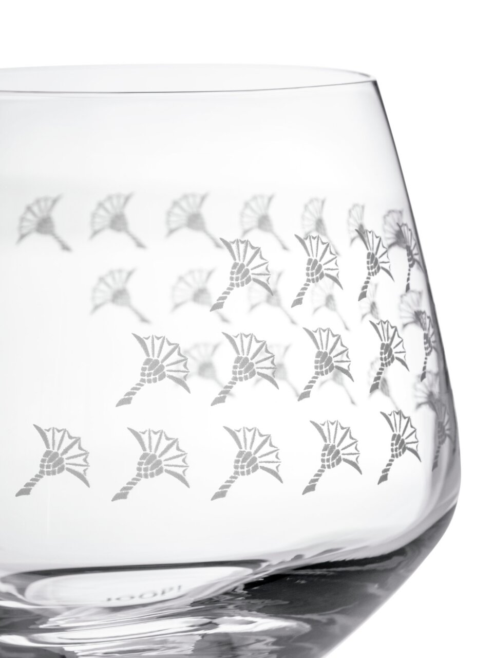 Nahaufnahme eines Wasserglases mit dekorativem Muster aus stilisierten Blumen, seitliche Perspektive.