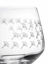Nahaufnahme eines Wasserglases mit dekorativem Muster aus stilisierten Blumen, seitliche Perspektive.