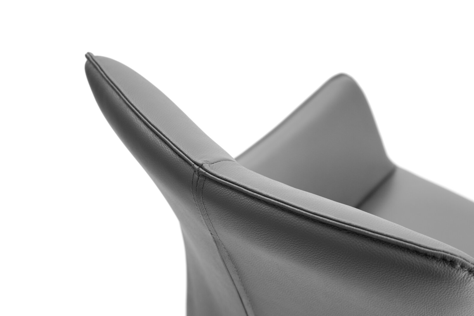 Close-up van een grijze leren fauteuil, gezien vanaf de zijkant