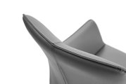 Close-up van een grijze leren fauteuil, gezien vanaf de zijkant