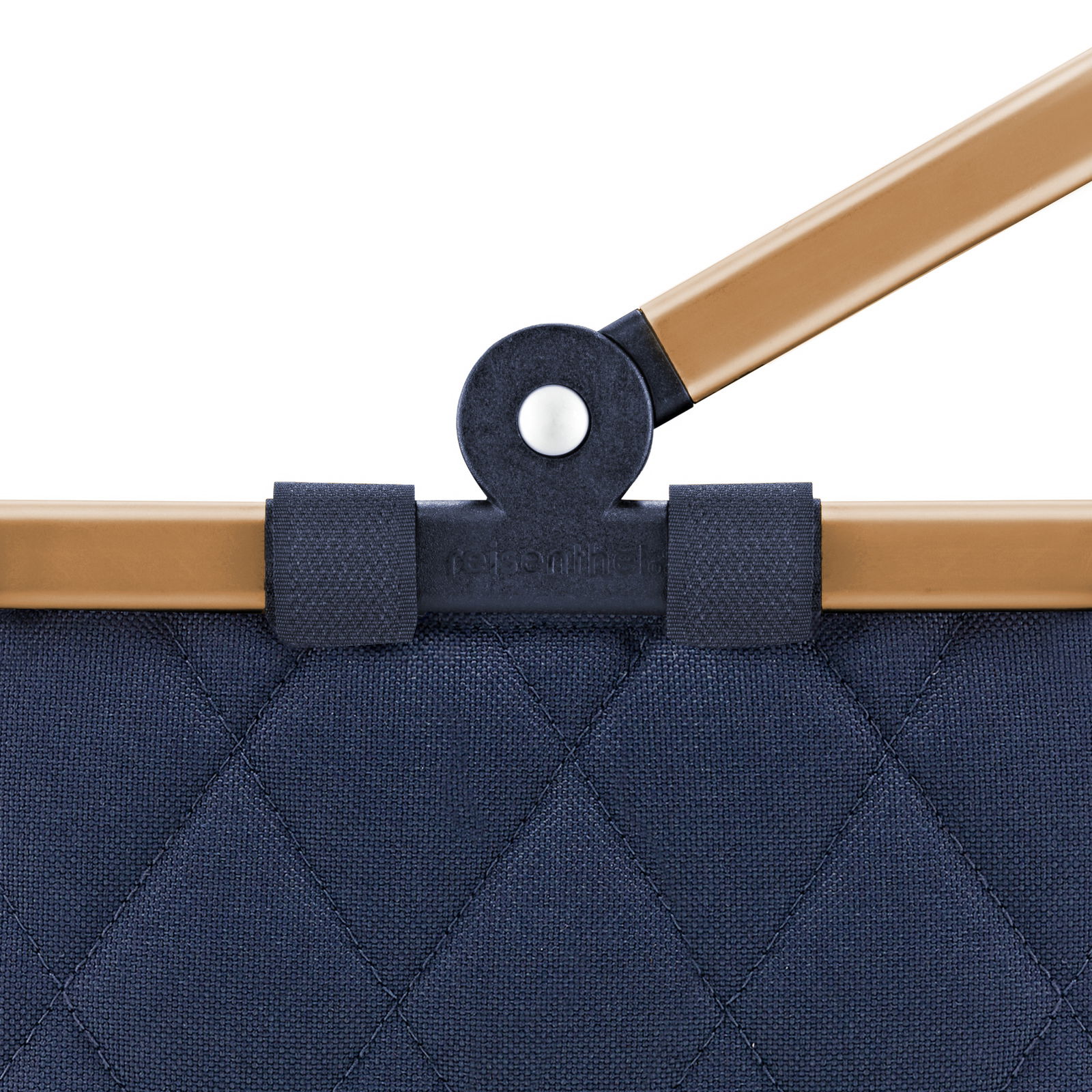 Nahaufnahme eines blauen, gesteppten carrybag XS mit braunem Griff und schwarzem Gelenk.