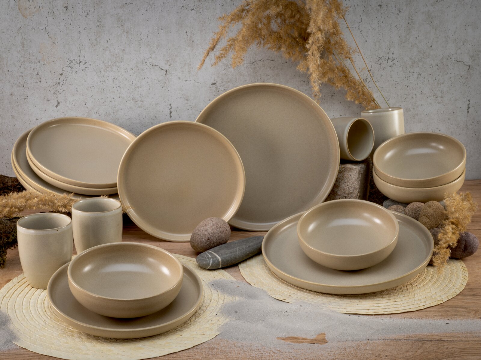 Kombiservice 16-tlg in natürlichem Beige, bestehend aus Tellern, Schalen und Tassen, auf einem Tisch mit dekorativen Elementen aus der Seitenperspektive.