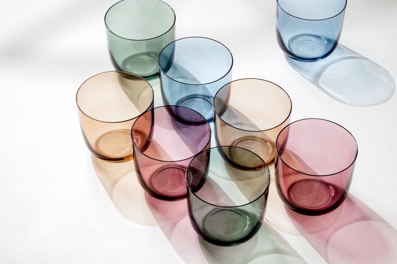 Bunte Wassergläser in verschiedenen Farben aus der Vogelperspektive.