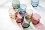 Bunte Wassergläser in verschiedenen Farben aus der Vogelperspektive.