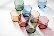 Bunte Wassergläser in verschiedenen Farben aus der Vogelperspektive.