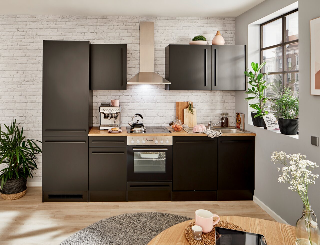 Moderne Küchenzeile in schwarzem Design mit Holzarbeitsplatte, Backofen, Herd und Dunstabzugshaube, frontal betrachtet.