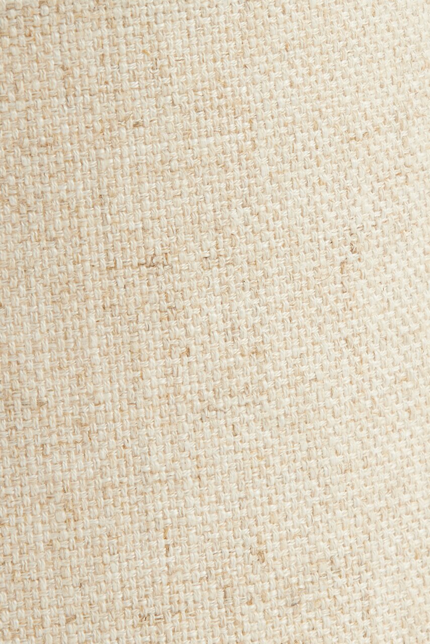 Nahaufnahme eines beigen, gewebten Lampenschirms mit texturierter Oberfläche.
