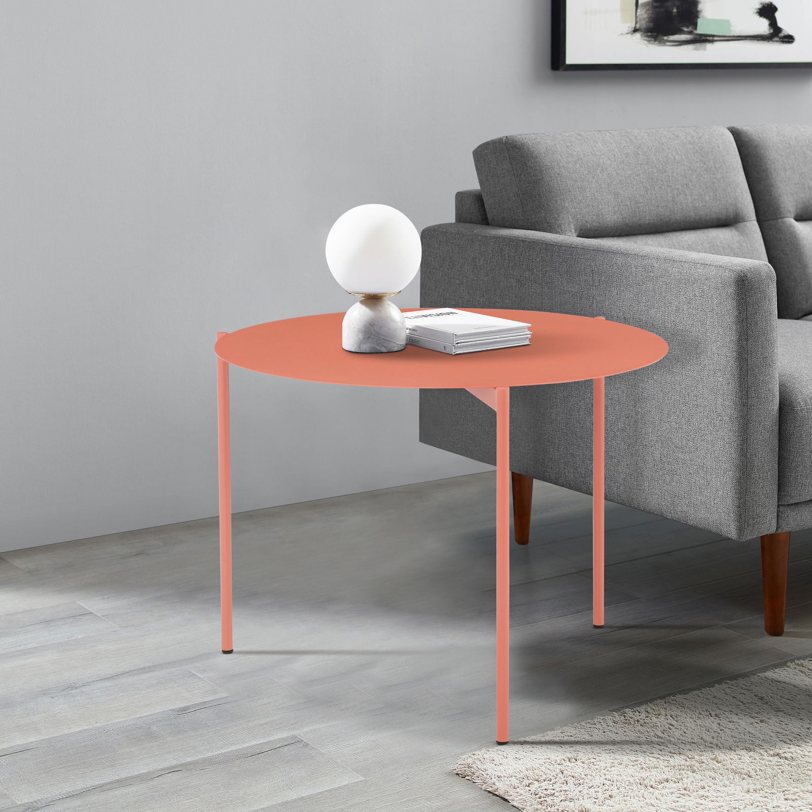 Z2 Beistelltisch rund JOCHEN Runder Beistelltisch in Korallenfarbe, seitliche Perspektive, neben einem grauen Sofa, dekoriert mit einer Lampe und Büchern.