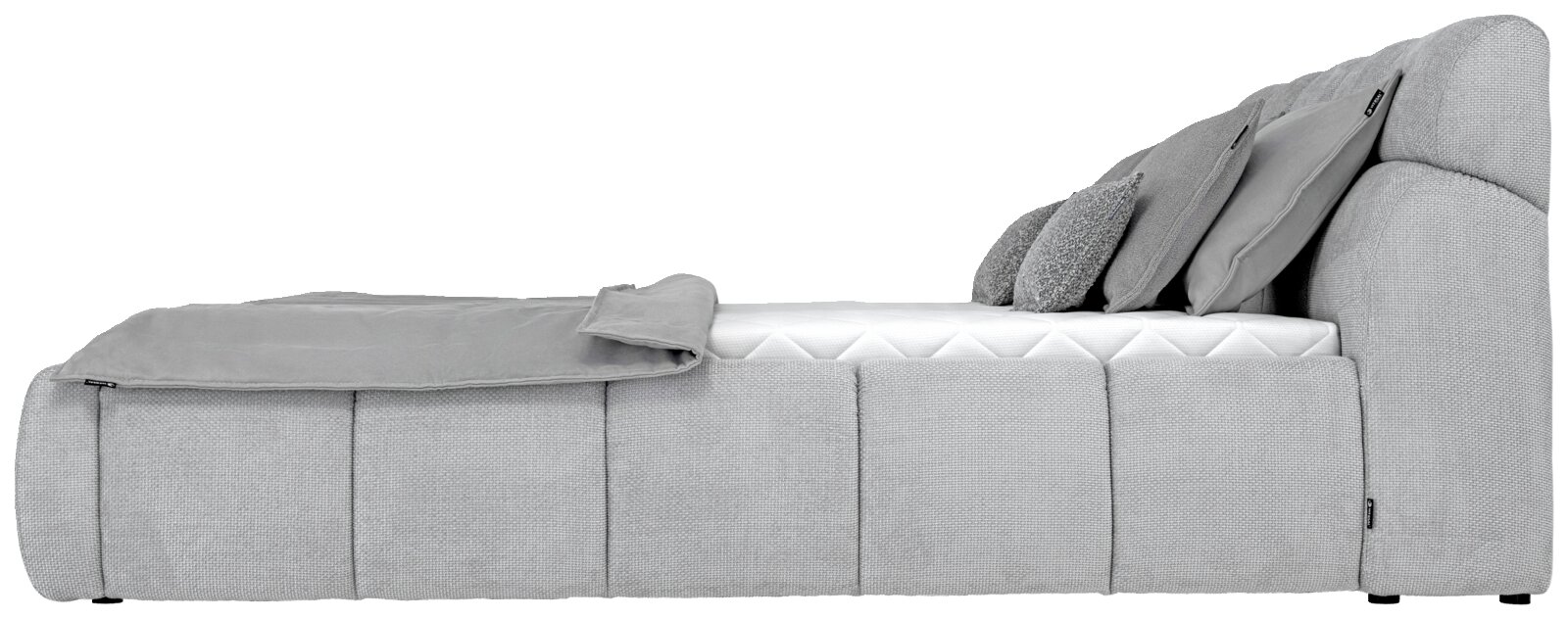 Seitliche Ansicht eines grauen Polsterbetts mit Kissen und Decke.
