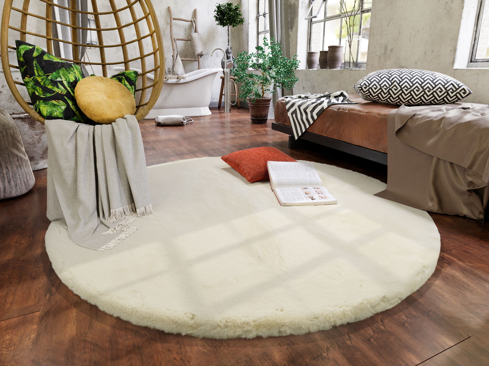 Runder, cremefarbener Fellteppich in einem gemütlichen Wohnzimmer mit hölzernem Boden, einem Hängesessel mit Kissen und einer offenen Zeitschrift auf dem Teppich. Perspektive von oben.