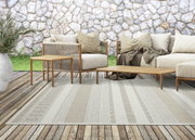 Moderner Outdoor-Teppich auf einer Holzterrasse mit stilvollen Gartenmöbeln, aus der Vogelperspektive fotografiert.