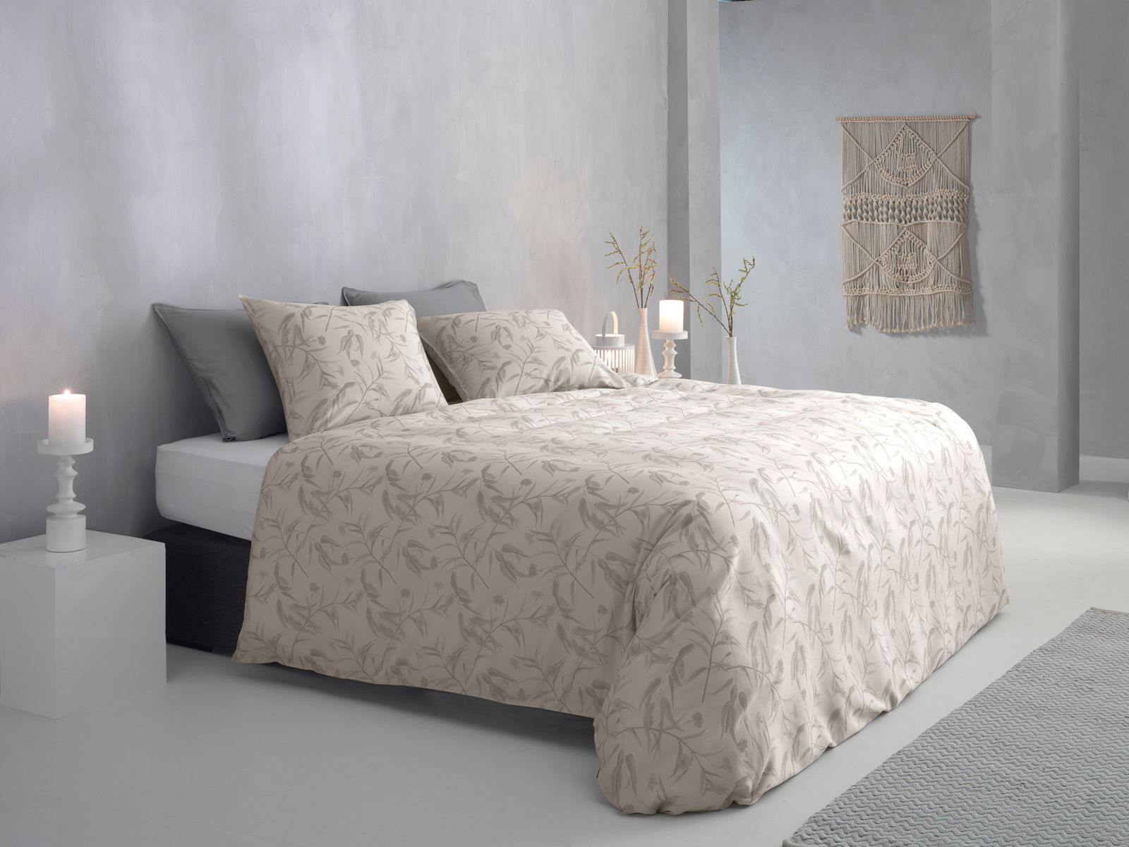 Bett mit floraler Bettwäsche in einem modernen, hellen Schlafzimmer, seitliche Perspektive