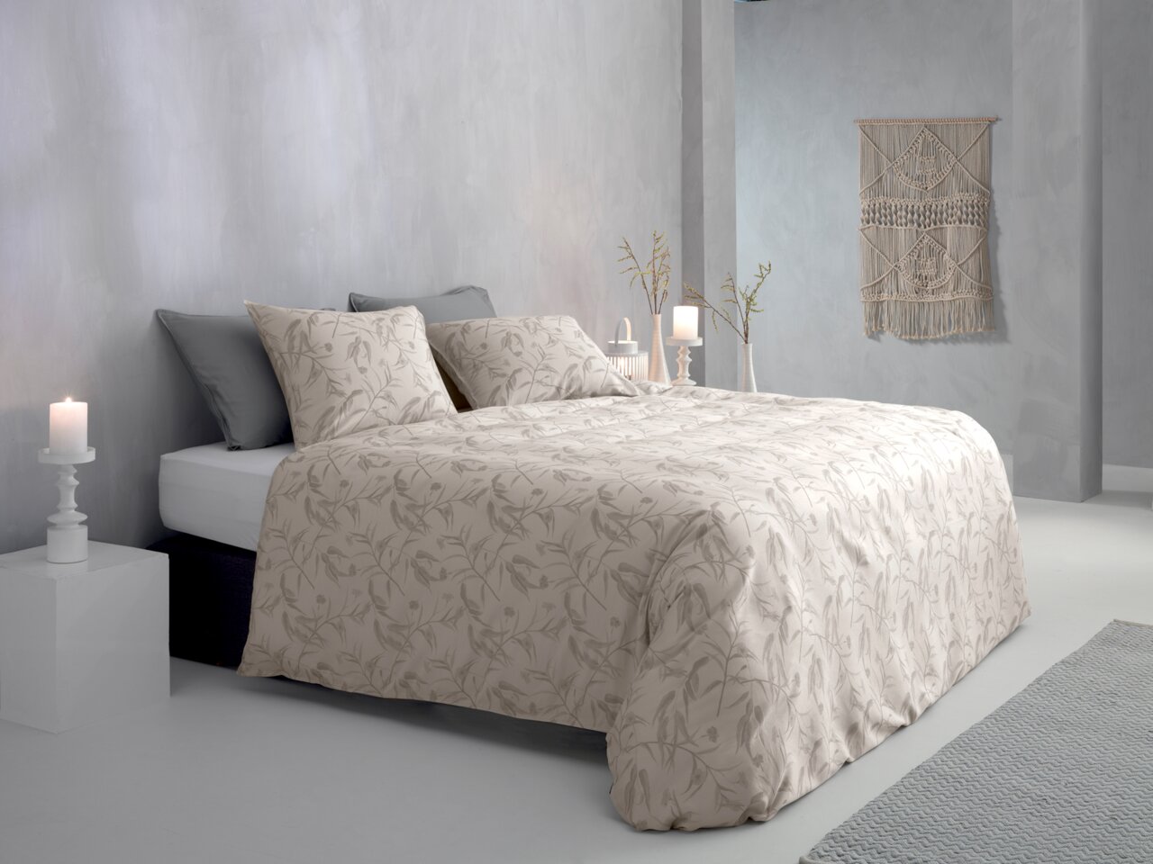 Bett mit floraler Bettwäsche in einem modernen, hellen Schlafzimmer, seitliche Perspektive
