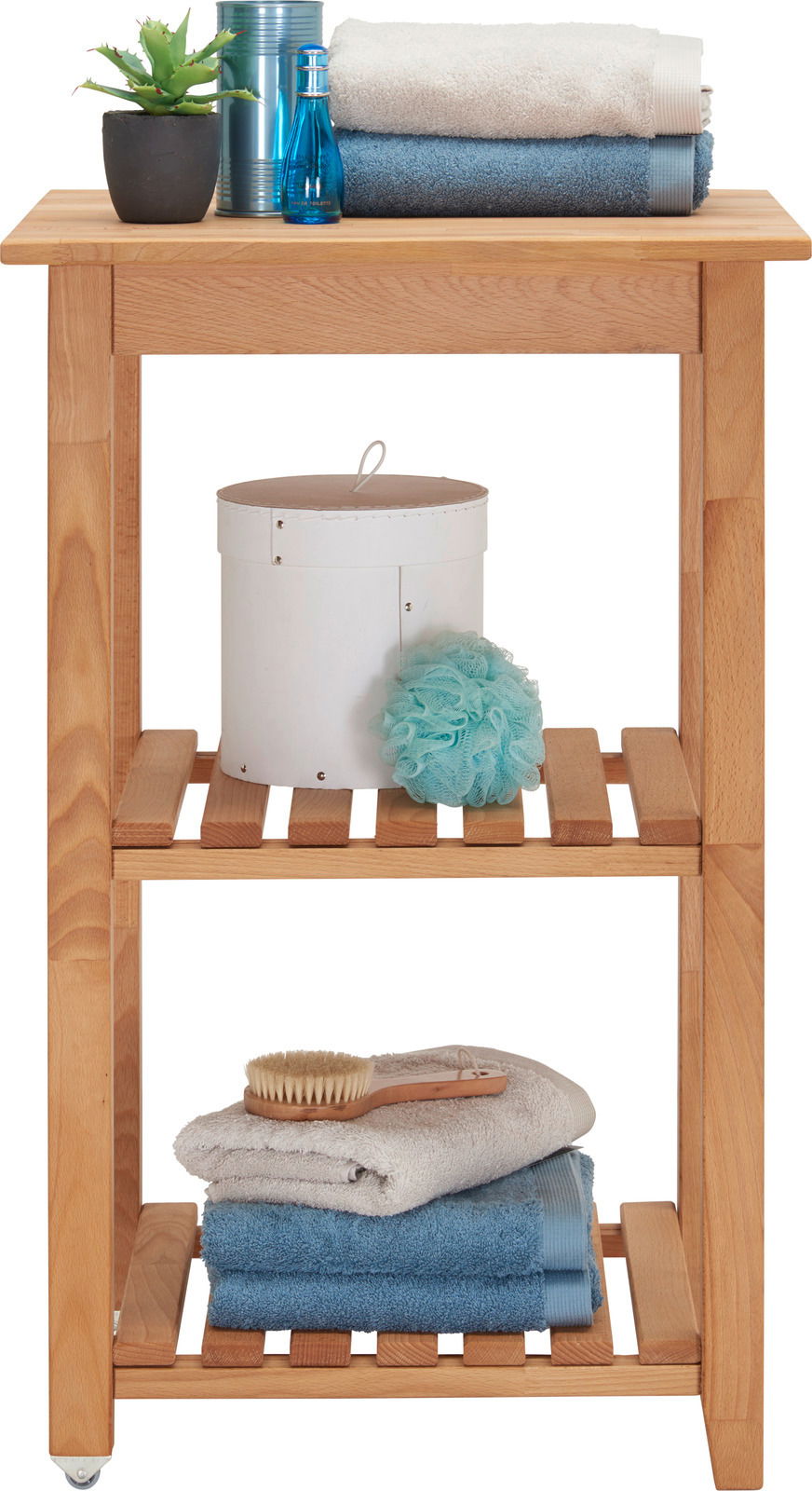 Holz-Servierwagen mit drei Ebenen, dekoriert mit Handtüchern, einer Pflanze und Pflegeprodukten, seitliche Perspektive