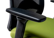 Nahaufnahme eines Drehstuhls mit schwarzer Armlehne und grünem Sitzpolster, seitliche Perspektive.