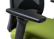 Nahaufnahme eines Drehstuhls mit schwarzer Armlehne und grünem Sitzpolster, seitliche Perspektive.