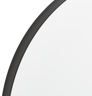 Nahaufnahme eines runden Spiegels mit schwarzem Rahmen, perspektivisch von der Seite aufgenommen.