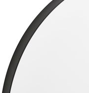 Nahaufnahme eines runden Spiegels mit schwarzem Rahmen, perspektivisch von der Seite aufgenommen.