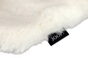 Nahaufnahme eines flauschigen weißen Stoffes mit einem schwarzen Etikett, auf dem 'JOOP!' steht. Perspektive von oben.