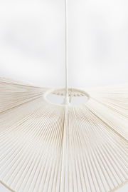 Nahaufnahme einer Hängeleuchte mit einem weißen, fächerförmigen Design aus gespannten Fäden, von unten betrachtet.