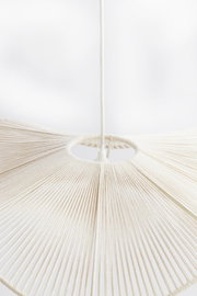 Nahaufnahme einer Hängeleuchte mit einem weißen, fächerförmigen Design aus gespannten Fäden, von unten betrachtet.