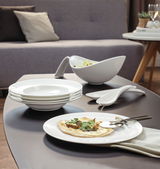 Elegantes Schalen-Set und Teller auf einem Tisch in moderner Wohnumgebung, seitliche Perspektive