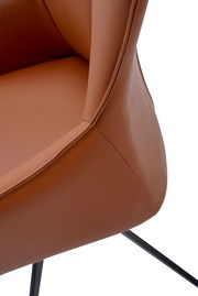 Nahaufnahme eines braunen Armlehnstuhls aus Leder mit schwarzem Metallgestell, seitliche Perspektive