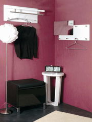 Moderne Wandgarderobe in einer Ecke mit lila Wänden, inklusive Kleiderbügel und Spiegel, aus der Frontalperspektive betrachtet.