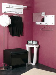 Moderne Wandgarderobe in einer Ecke mit lila Wänden, inklusive Kleiderbügel und Spiegel, aus der Frontalperspektive betrachtet.