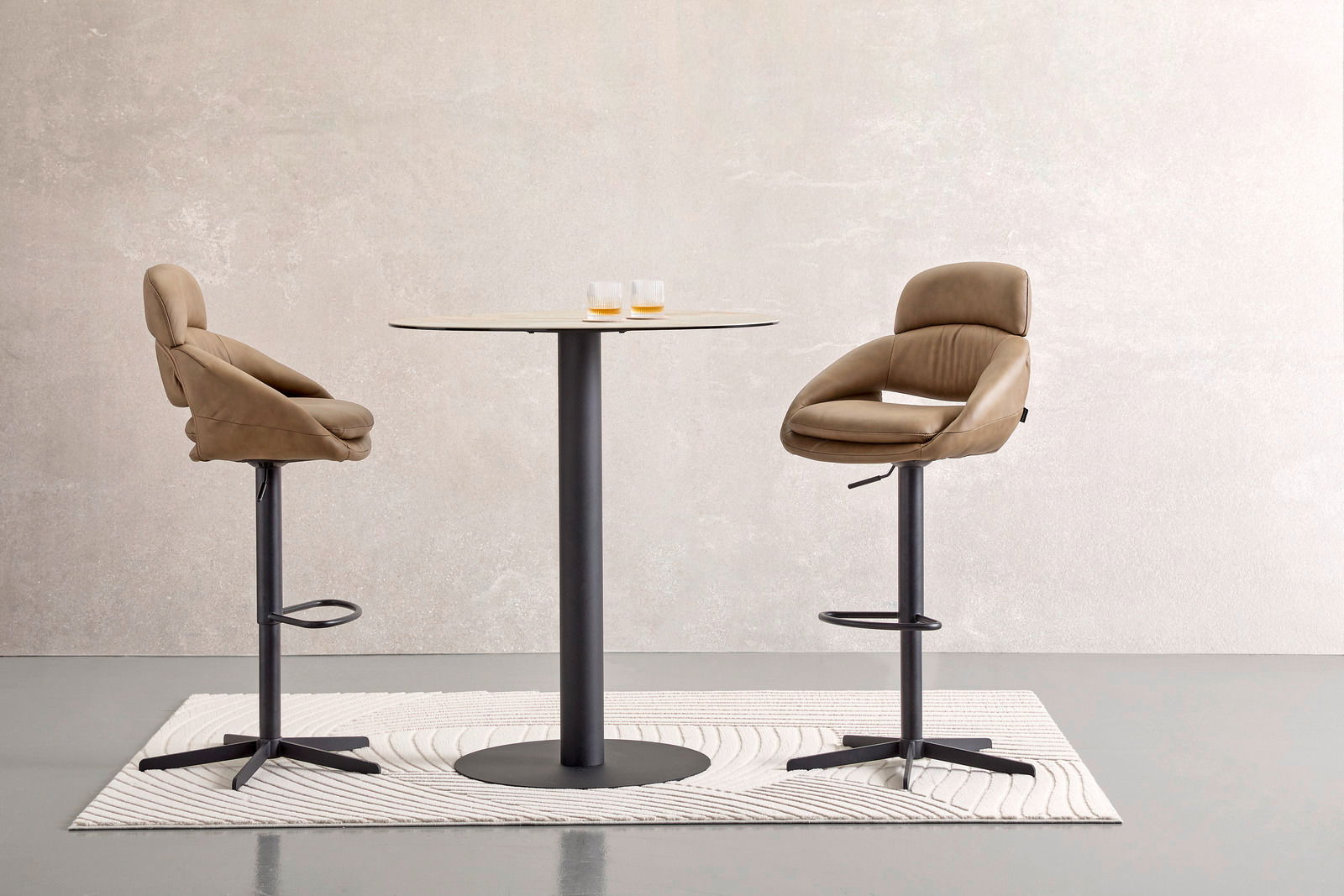Moderner Bartisch mit zwei beigen Barhockern, seitliche Perspektive