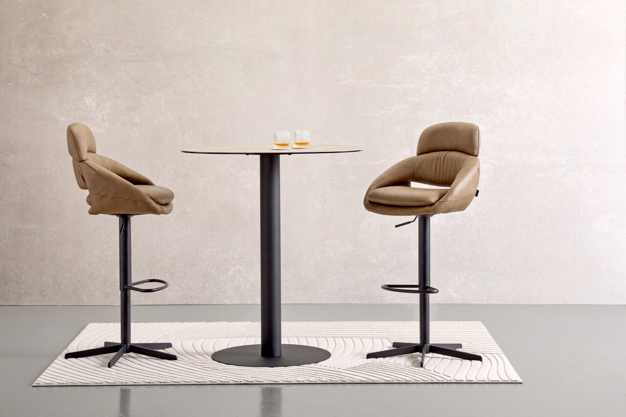 Moderne bartafel met twee beige barkrukken, zijaanzicht