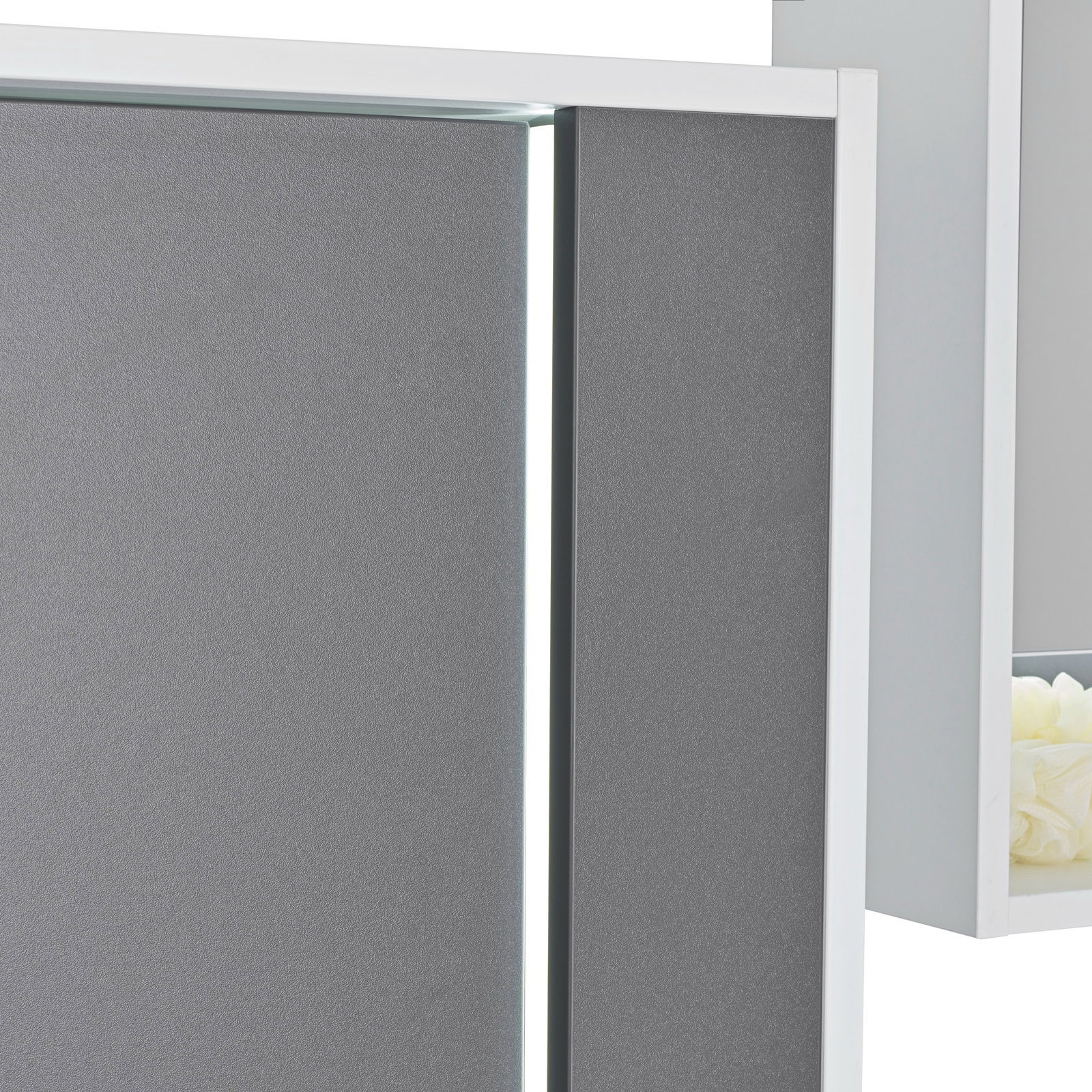 Nahaufnahme eines grauen Midischranks mit weißem Rahmen und moderner, minimalistischer Gestaltung.
