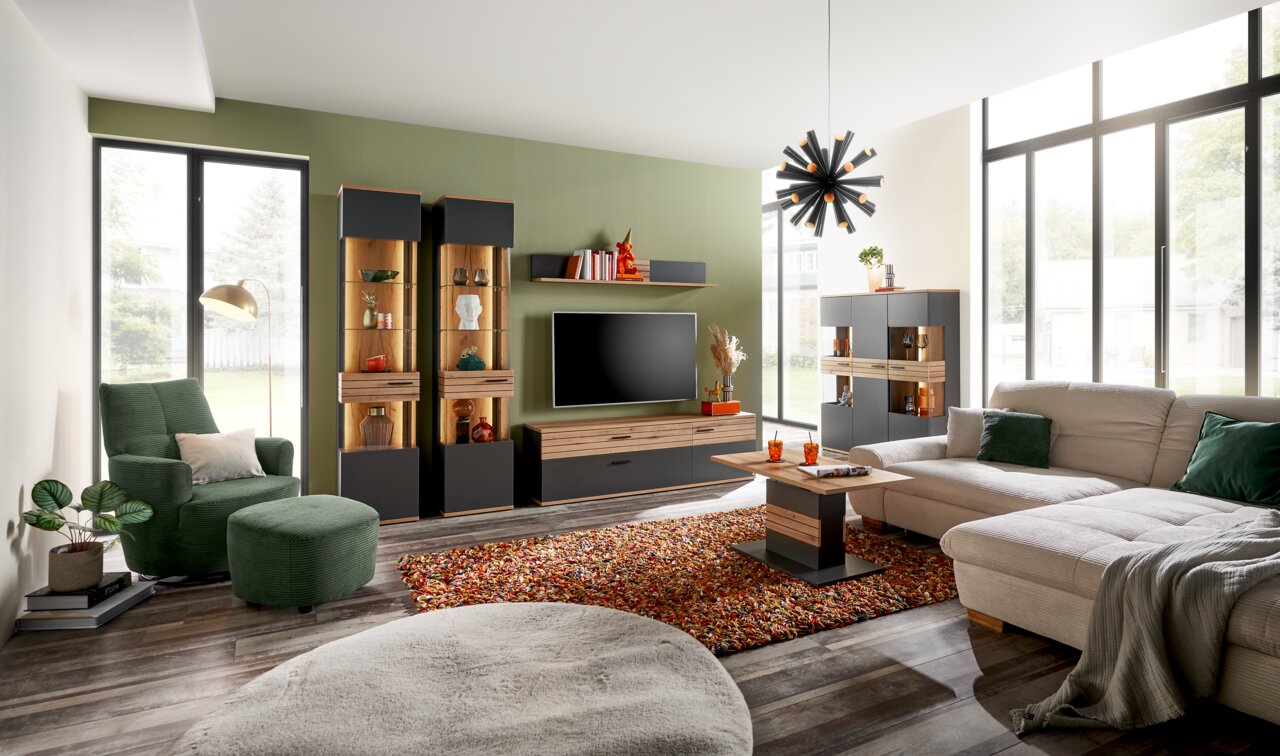 Set one by Musterring Vitrine SET ONE QUINCY Moderne Wohnzimmermöbel in einem stilvollen Raum mit großen Fenstern, bestehend aus Vitrinen, TV-Lowboard, Sideboard und Couchtisch in dunklen und holzfarbenen Tönen. Perspektive: Frontalansicht.