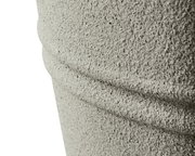 Nahaufnahme eines strukturierten, grauen Objekts aus recyceltem Kunststoff mit horizontalen Rillen, seitliche Perspektive.