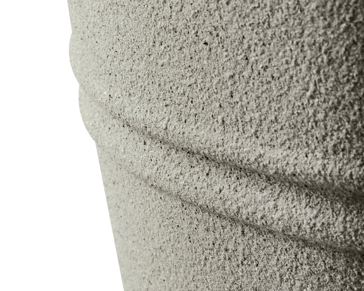 Nahaufnahme eines strukturierten, grauen Objekts aus recyceltem Kunststoff mit horizontalen Rillen, seitliche Perspektive.