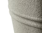 Nahaufnahme eines strukturierten, grauen Objekts aus recyceltem Kunststoff mit horizontalen Rillen, seitliche Perspektive.