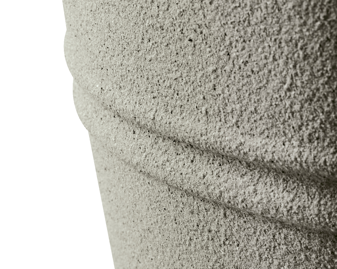 Nahaufnahme eines strukturierten, grauen Objekts aus recyceltem Kunststoff mit horizontalen Rillen, seitliche Perspektive.