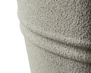 Nahaufnahme eines strukturierten, grauen Objekts aus recyceltem Kunststoff mit horizontalen Rillen, seitliche Perspektive.