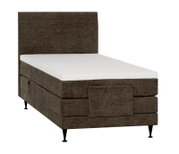 Bruin gestoffeerd boxspringbed met hoog hoofdbord, witte matras, voetbord en zwarte poten, schuin van voren en opzij gezien.