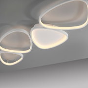 Moderne weiße LED-Deckenleuchte mit vier abgerundeten, ringförmigen Lichtflächen und warmweißem Licht, fotografiert aus der Untersicht schräg von unten.