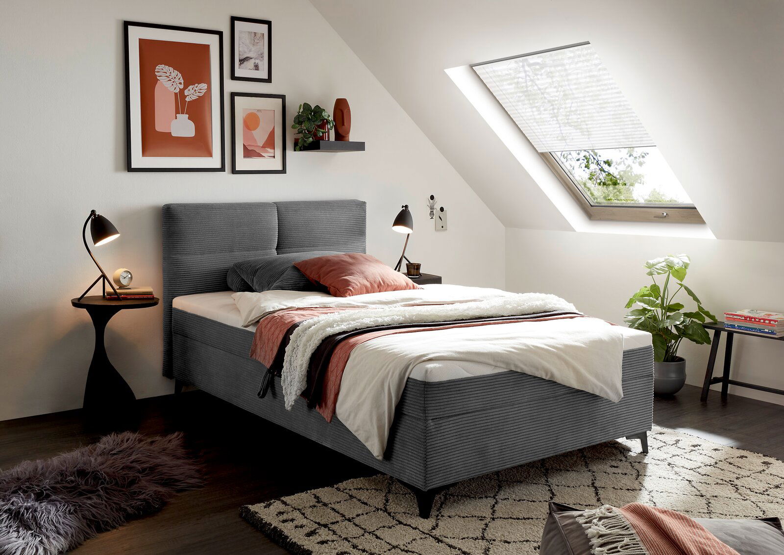 Gemütliches Boxbett in modernem Schlafzimmer mit Dachfenster, dekorativen Bildern und Pflanzen, seitliche Perspektive.