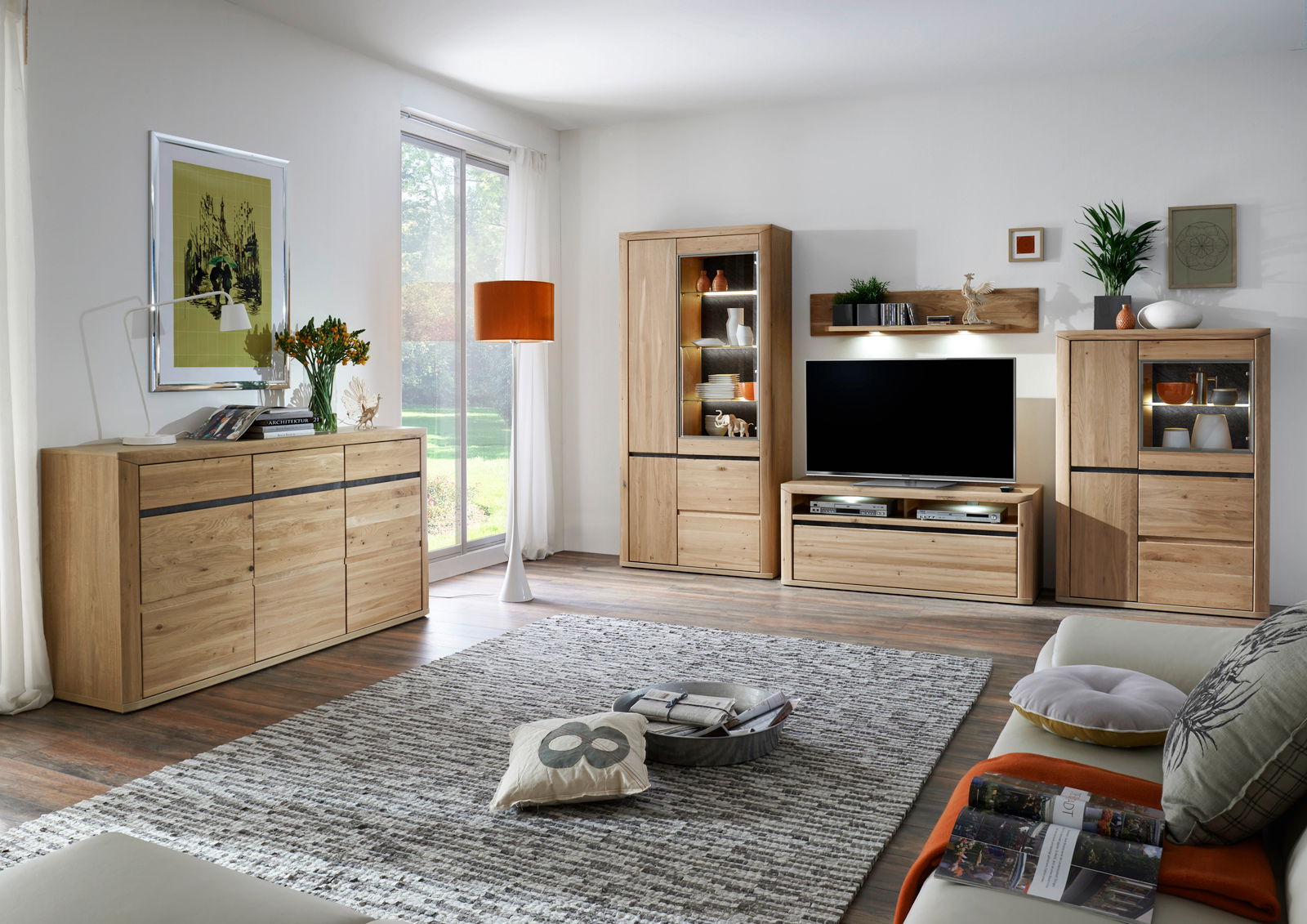Modernes Wohnzimmer mit einem Sideboard aus Holz, das links im Raum steht. Die Perspektive zeigt das Sideboard von vorne, umgeben von stilvoller Dekoration und einem großen Fenster im Hintergrund.