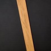 Nahaufnahme eines Esstischs mit einer Holzplatte und schwarzer Oberfläche, diagonale Perspektive.