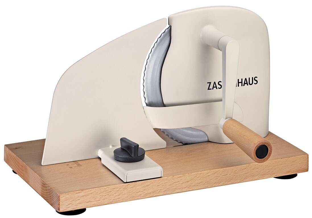 Crèmekleurige handmatige broodsnijmachine met kartelmes, houten basis en houten slingerhandvat, zijaanzicht schuin van voren