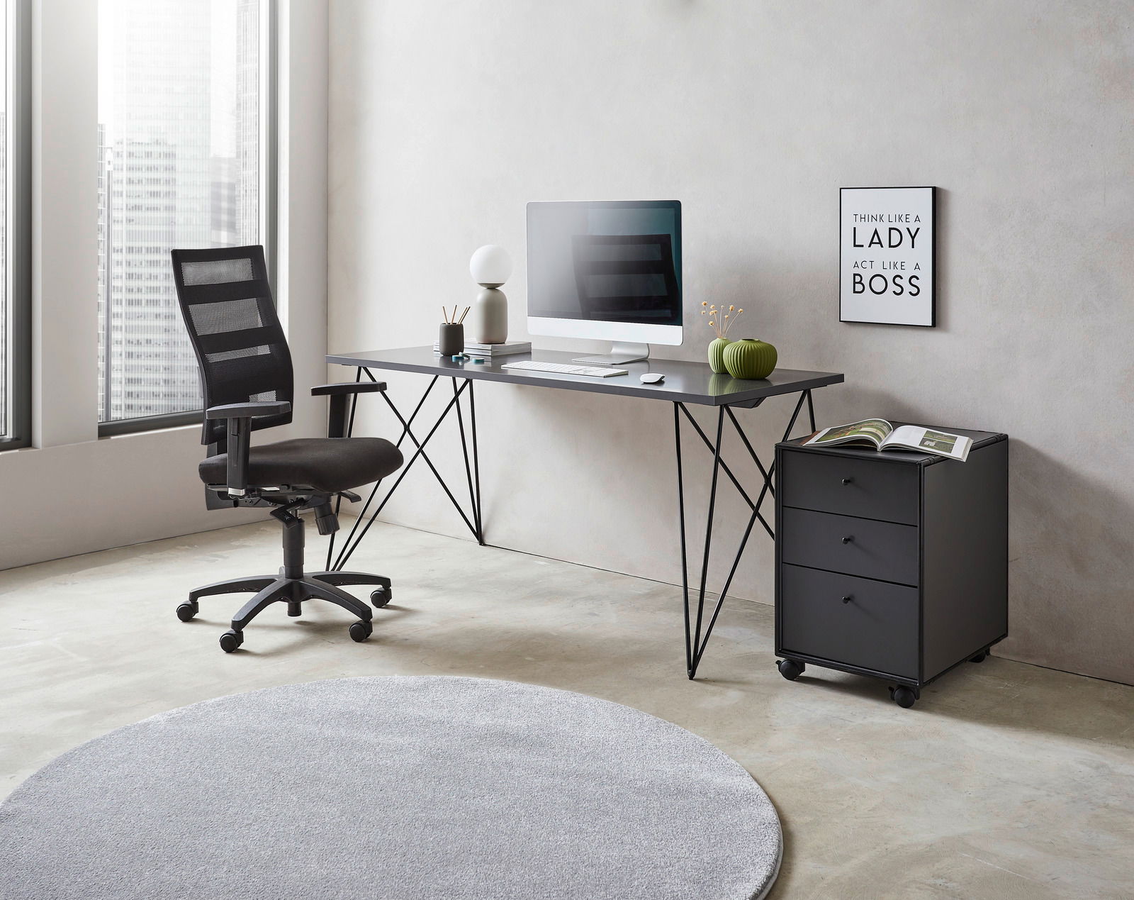 Moderner Schreibtisch mit schwarzem Metallgestell, Computer und Dekorationen, seitliche Perspektive