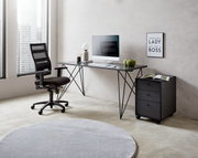 Moderner Schreibtisch mit schwarzem Metallgestell, Computer und Dekorationen, seitliche Perspektive